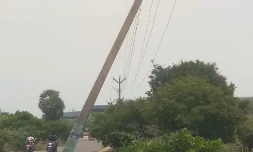 சாய்ந்து நிற்கும் மின்கம்பம்
