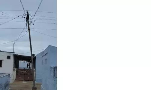 சாய்ந்த மின்கம்பத்தால் அச்சத்தில் மக்கள்